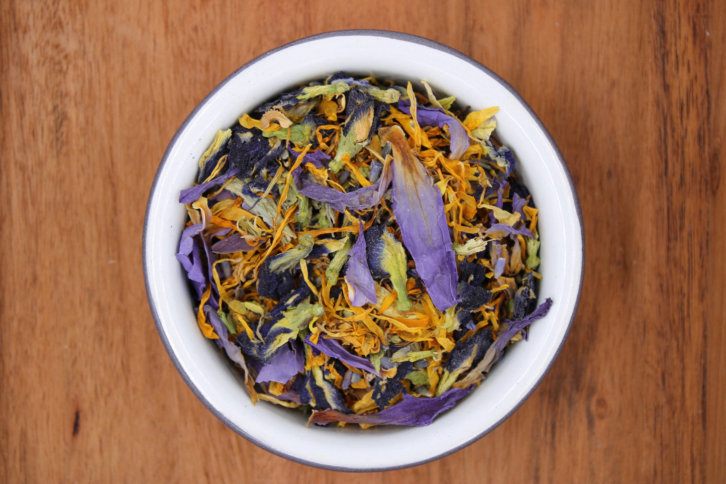 Close-up of a vibrant loose-leaf tea blend featuring a colorful array of calming botanicals, including Butterfly Pea Flower, Blue Lotus Flower, California Poppy Flower, French Super Blue Lavender Flower, Calendula Flower, and Passionflower. This premium sleep tea is designed for relaxation and peaceful bedtime routines. Perfect for tea lovers seeking natural wellness and tranquility.
